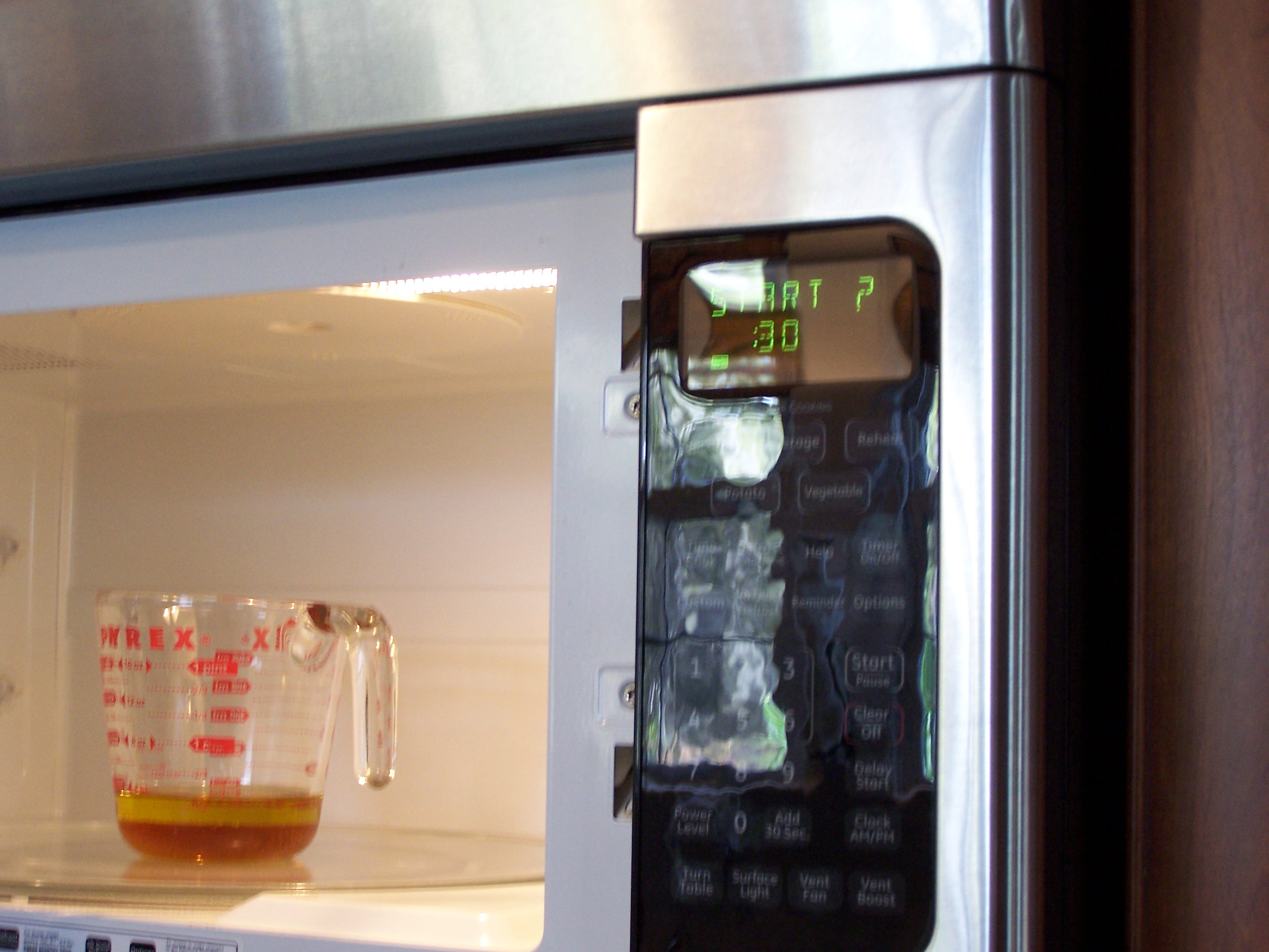 measuring cup with olive oil and honey, ingredients in the microwave