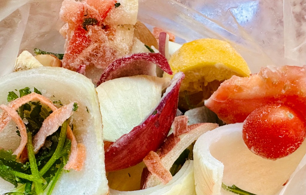 Frozen vegetable scraps in a zip top bag