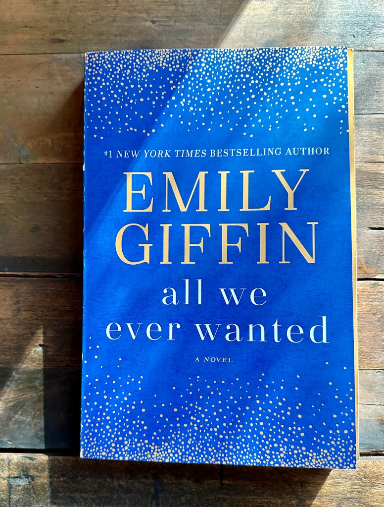 Book on a table, blue book, gold writing, #1 New York Times Bestselling Author, Emily Giffin, All We Ever Wanted