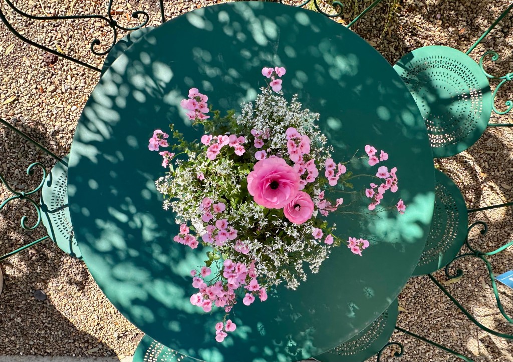 wonderful green round table, green chairs with round seats and dainty curves, gorgeous pink flowers on a plan on the table, image taken from above
