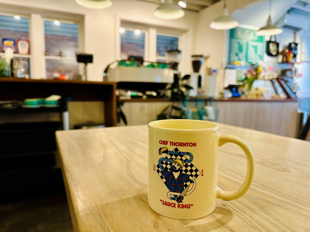 Chef Thornton, coffee mug, donation, mug on table overlooking Orchard coffee shop