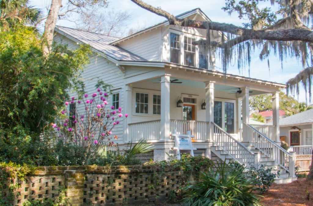 Beautiful home with porch under a live oak tree dripping with Spanish moss