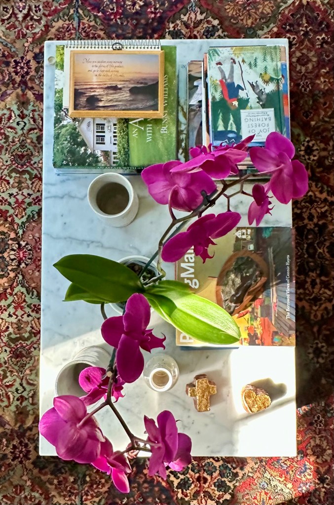 marble table with books, an orchid, a cross, heart and vases
