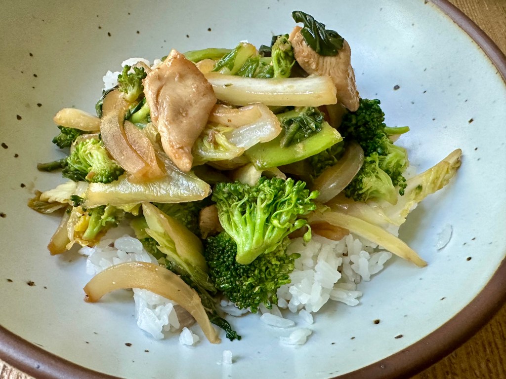 stir fry with white rice, broccoli florets, napa cabbage, bok choy and snow peas in a pretty bowl